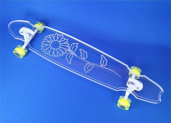 clear longboard with a sunflower engraved onto the top of it